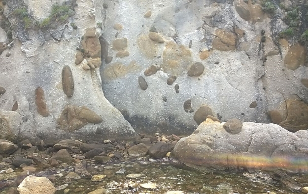 Meter große Basalttropfen im Granit am Cap San Andrea. Außerdem bis zu 10 cm große, weiße Feldspat-Kristalle